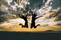 Horizontal silhouette of two friends jumping high under the breathtaking cloudy sky during sunset Royalty Free Stock Photo
