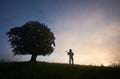 Horizontal snapshot of two figures on purple sky background, of a spaceman and a tree Royalty Free Stock Photo