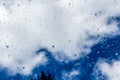 A horizontal texture of water droplets is on the glass and on a background of blue sky Royalty Free Stock Photo