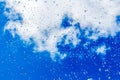 A horizontal texture of water droplets is on the glass and on a background of blue sky Royalty Free Stock Photo