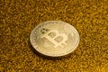 Single bitcoin coin on golden glittering background