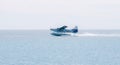 Horizontal view of a blue and white seaplane landing in Dry Tortugas, United States in spring