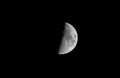 Horizontal view of a clear bright half moon in a black night sky Royalty Free Stock Photo