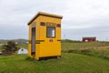 Horizontal view of cute handmade yellow school bus shelter seen during a fall cloudy morning