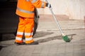 Horizontal View of a Dustman Cleaning the Street With a Mop Wear