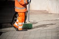 Horizontal View of a Dustman Cleaning the Street With a Mop Wear