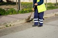 Horizontal View of a Dustman Working in the Street Using a Wooden Mop and Dressing a Yellow Jacket