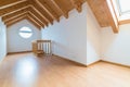 Empty spacious and bright attic in a refurbished apartment with wooden parquet floor and white walls and wooden gable roof Royalty Free Stock Photo