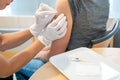 Horizontal view of a female doctor disinfecting a female patient`s arm after a vaccination