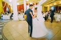 The horizontal view of the happy dancing newlywed couple in the restaurant.