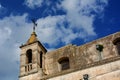 Horizontal View of an Historical Buinding With a Crux on Cloudy