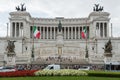 Horizontal view of Italian flags and facade of Vittoriano monument, symbol of Italian union, on a cloudy day