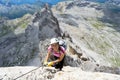 Pretty female climber in lilac shirt on a steep Via Ferrata in the italian Dolomites