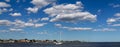 Horizontal view of puffy clouds over sailboat in Great South Bay