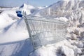 Horizontal view of shopping cart encased in ice after ice storm seen in snow bank