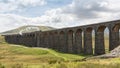 Horizontal view of a steam train crossing the Ribble Head viaduct in north Yorkshire