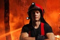 A strong, athlete fireman in helmet with crossed hands, looking at camera, during the forest fire fight. Royalty Free Stock Photo