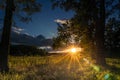 Horizontal view of the sun setting over a huge grassy field on the historic Testimonial