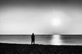 Horizontal vivid black and white lonely man meeting ocean sunset Royalty Free Stock Photo