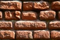 Horizontal wall texture of several rows of very old brickwork made of red brick. Shattered and damaged brick wall with pinched co Royalty Free Stock Photo