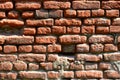 Horizontal wall texture of several rows of very old brickwork made of red brick. Shattered and damaged brick wall with pinched co Royalty Free Stock Photo