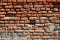 Horizontal wall texture of several rows of very old brickwork made of red brick. Shattered and damaged brick wall with pinched co Royalty Free Stock Photo