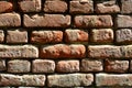 Horizontal wall texture of several rows of very old brickwork made of red brick. Shattered and damaged brick wall with pinched co Royalty Free Stock Photo