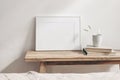 Horizontal white frame mockup on vintage wooden bench, table. Ceramic mug with dry Lagurus ovatus grass and books. White