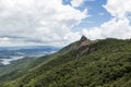 Horizontal wide angle view of a mountain rock face with some trees under a blue sky with white clouds - pico e serra do lopo Royalty Free Stock Photo