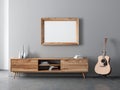 Horizontal Wooden Frame poster Mockup hanging above console and acoustic guitar Royalty Free Stock Photo