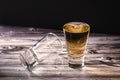 Horizontally oriented chopped view of a shot of whiskey or scotch or bourbon next to a second dropped shot Royalty Free Stock Photo