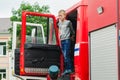 HORKI, BELARUS - JULY 25, 2018: The boy looks out of the 112 red rescue service car on a holiday in the park on a summer day