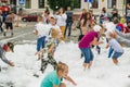 HORKI, BELARUS - JULY 25, 2018: Children of different ages play with white foam in the park at a party in summer day