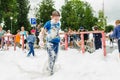 HORKI, BELARUS - JULY 25, 2018: A little fair-haired boy plays with airy white foam at the Rescue Service 112 holiday amid a crowd