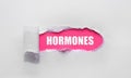 HORMONES medical word written under torn paper