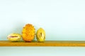 Horned Melon and Pepinos on wooden shelf