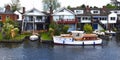 Waterside properties and old fashioned cruiser on the river Bure at Horning. Royalty Free Stock Photo