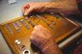 Horologist arranging watch strap on wooden board