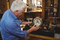 Horologist checking a clock in workshop Royalty Free Stock Photo