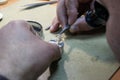 Horology artisan with tongs fixing a wristwatch