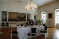 Horovice castle interior, Baroque chateau, Dining room with carved wooden white furniture, table with tablecloth porcelain,