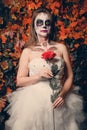 Horrible makeup on a girl with rose in a bride dress for Halloween