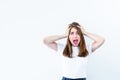 Horrible, stress, shock. Young emotional suprised woman looks at camera, clasping head in hands and opening her mouth isolated on Royalty Free Stock Photo