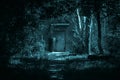 Horror concept, a path to the entrance of a house door through a scary dark night forest among trees with a mystical Royalty Free Stock Photo