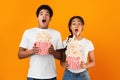 Horror film. Frightened couple throwing popcorn over background