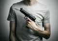 Horror and firearms topic: suicide with a gun on a gray background in the studio