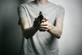 Horror and firearms topic: suicide with a gun on a gray background in the studio Royalty Free Stock Photo