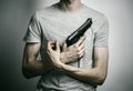 Horror and firearms topic: suicide with a gun on a gray background in the studio Royalty Free Stock Photo