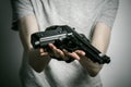 Horror and firearms topic: suicide with a gun on a gray background in the studio Royalty Free Stock Photo