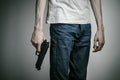 Horror and firearms topic: suicide with a gun on a gray background in the studio Royalty Free Stock Photo